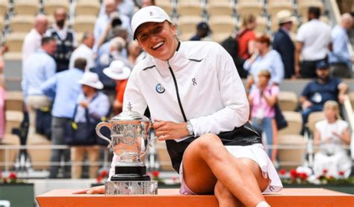 A smiling Iga Swiatek with Roland Garros trophy